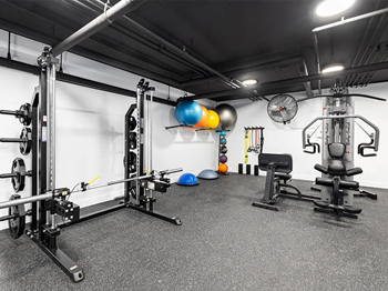 Fitness center including cycling bikes, ellipticals, treadmills, free weights, and stretching balls.