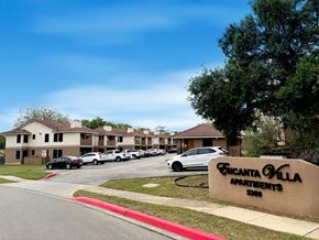 San Antonio apartment for rent - A sign for Encanta Villa Apartments is in front of a row of parked cars.
