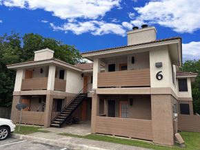 San Antonio apartment for rent - A two story house with a car parked in front.