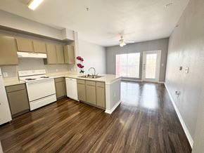 San Antonio apartment for rent - A kitchen with white appliances and brown wood floors.