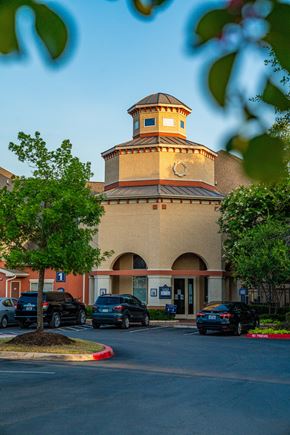 San Antonio apartment for rent - A building with a round tower and a parking lot in front.