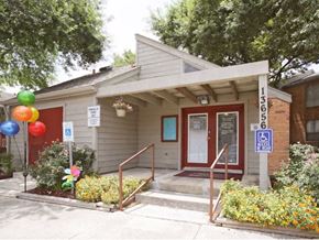 San Antonio apartment for rent - Exterior of leasing office with beige paint and red door framing