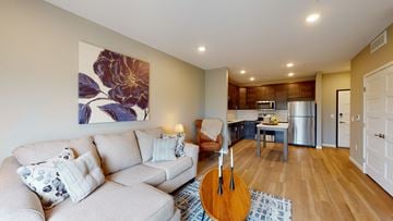 Rochester apartment for rent - A living room with a couch, a guitar, and a painting on the wall.
