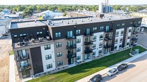 Yankton apartment for rent - A modern apartment building with a parking lot in front.
