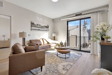 Yankton apartment for rent - A living room with a brown couch and a painting on the wall.