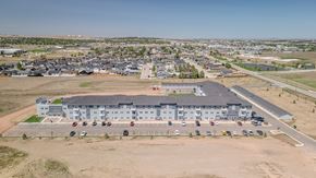 Gillette apartment for rent - A large building with a parking lot in front of it.