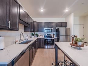 Gillette apartment for rent - A modern kitchen with dark wood cabinets and stainless steel appliances.