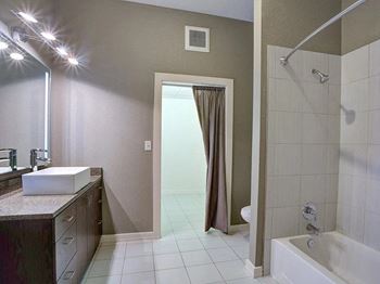 A bathroom with a shower and a sink and a bath tub