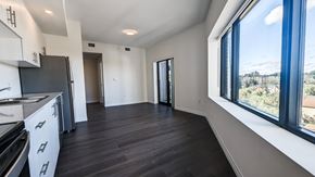 Kitchener apartment for rent - A kitchen with white cabinets and a black fridge is shown.