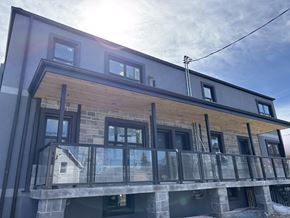 Kitchener apartment for rent - A modern house with a balcony and a glass railing.