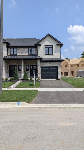 Ingersoll townhouse for rent - a house with a driveway and a garage door