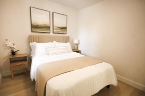Kitchener apartment for rent - A bedroom with a large bed and two framed pictures on the wall.