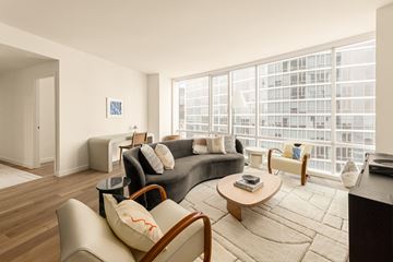New Rochelle apartment for rent - A living room with a grey couch and a coffee table.