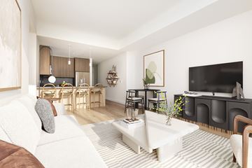 New Rochelle apartment for rent - A living room with a white couch and a television.
