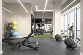 Secaucus apartment for rent - Interior photo of the gym at RVR showing an elliptical facing out the large windows with a view of the water, as well as various strength training areas.