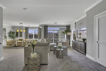 West Windsor apartment for rent - A living room with a grey sofa and a vase of flowers on a table.