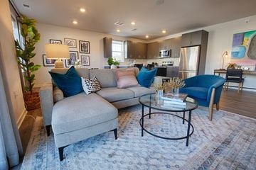 Pennington apartment for rent - A living room with a grey couch and a blue chair.