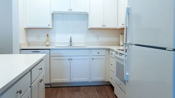 Kissimmee apartment for rent - A white kitchen with a refrigerator on the right.