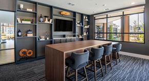 Grand Prairie apartment for rent - A modern dining room with a long table and grey chairs.