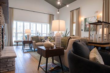Lagrange apartment for rent - A living room with a grey couch and a table with a vase on it.