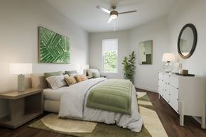 Kissimmee apartment for rent - A bedroom with a large bed and a ceiling fan.