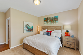 Burlington apartment for rent - a bedroom with beige walls and a bed with white sheets and pillows