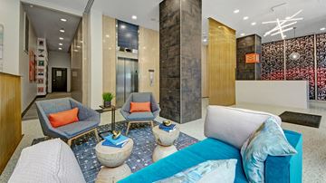Dallas apartment for rent - A living room with a grey sofa, two chairs and a table.