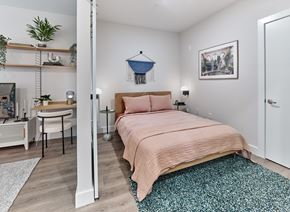 Rahway apartment for rent - Chic bedroom area in a studio apartment at The Mint Rahway, featuring a comfortable bed, workspace, and stylish decor.