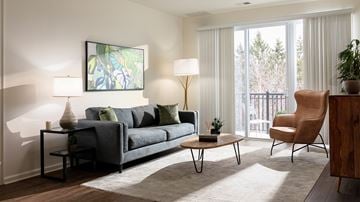Bound Brook apartment for rent - A living room with a grey couch, a wooden table, and a painting on the wall.