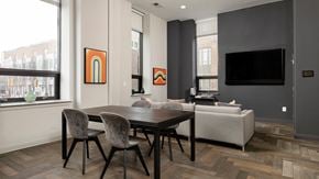 Philadelphia apartment for rent - Spacious resident lounge with a large-screen TV and herringbone flooring, typical of upscale Rittenhouse Square apartments Philadelphia PA.