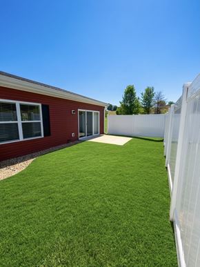 Independence apartment for rent - A red building with a white fence and green grass in front.