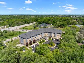 Woodbury apartment for rent - A large building surrounded by trees and a parking lot.