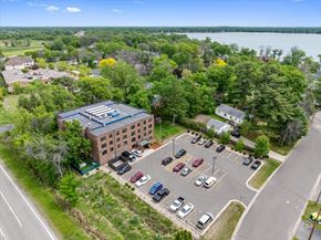 Forest Lake apartment for rent - A parking lot with cars and a building in the background.
