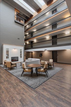 Forest Lake apartment for rent - A modern living room with a fireplace and a dining table.
