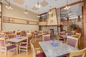 Forest Lake apartment for rent - A dining room with tables and chairs and a clock on the wall.