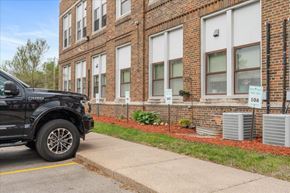 St. Paul Park apartment for rent - A black truck is parked on the side of a street in front of a brick building.