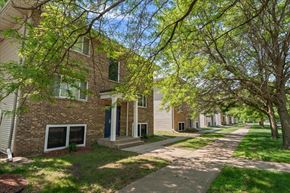 St. Paul Park apartment for rent - A tree-lined street with apartment buildings on either side.