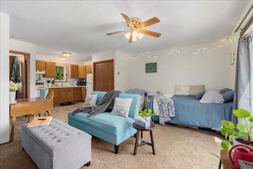 Stillwater townhouse for rent - A living room with a blue couch and a ceiling fan.