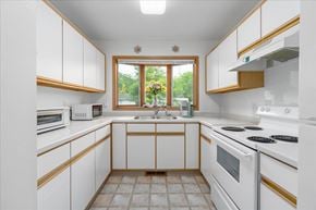 Scandia apartment for rent - A kitchen with white cabinets and a window.
