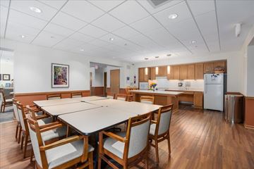Woodbury apartment for rent - A kitchen with a table and chairs in the foreground and a refrigerator in the background.