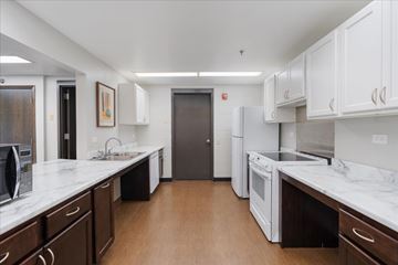 Forest Lake apartment for rent - A kitchen with white cabinets and a marble countertop.