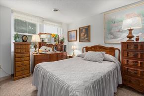 St. Paul Park apartment for rent - A bedroom with a large bed, a dresser, and a nightstand.