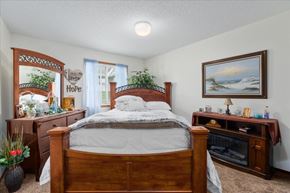 Forest Lake apartment for rent - A bedroom with a bed, dresser, and a painting on the wall.
