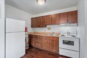 St. Paul Park apartment for rent - A kitchen with wooden cabinets and white appliances.