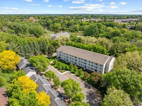 Stillwater townhouse for rent - A large white building surrounded by trees and a parking lot.