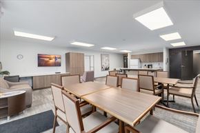 Hugo apartment for rent - A modern dining room with a large wooden table and chairs.