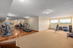 Forest Lake apartment for rent - A spacious room with exercise equipment and a large window.