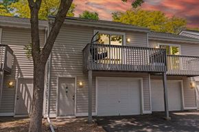 Stillwater townhouse for rent - A two-story house with a balcony and garage doors.