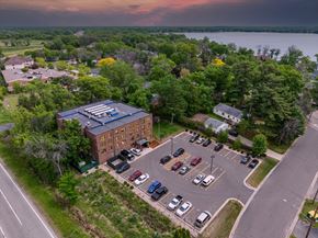 Forest Lake apartment for rent - A parking lot with cars and a building in the background.