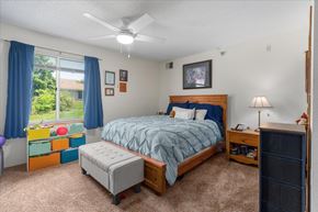 Stillwater apartment for rent - A bedroom with a bed, nightstand, and window with blue curtains.